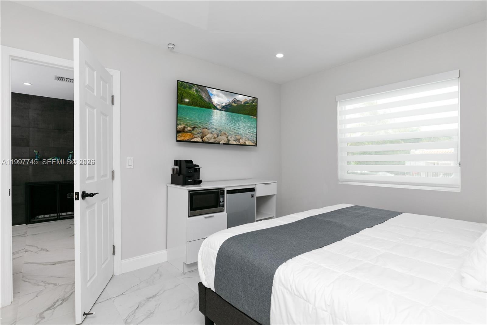 2376 Northwest 2nd Street Miami, FL 33125 - Photo 42 of 77 a bedroom with a bed and a flat screen tv