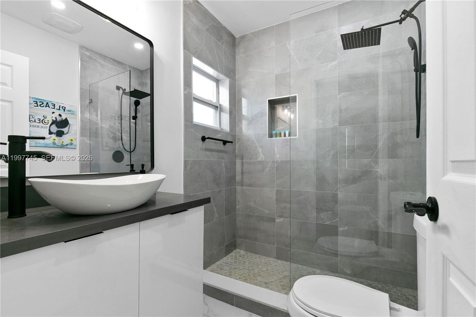 2376 Northwest 2nd Street Miami, FL 33125 - Photo 43 of 77 a bathroom with a granite countertop sink toilet and shower