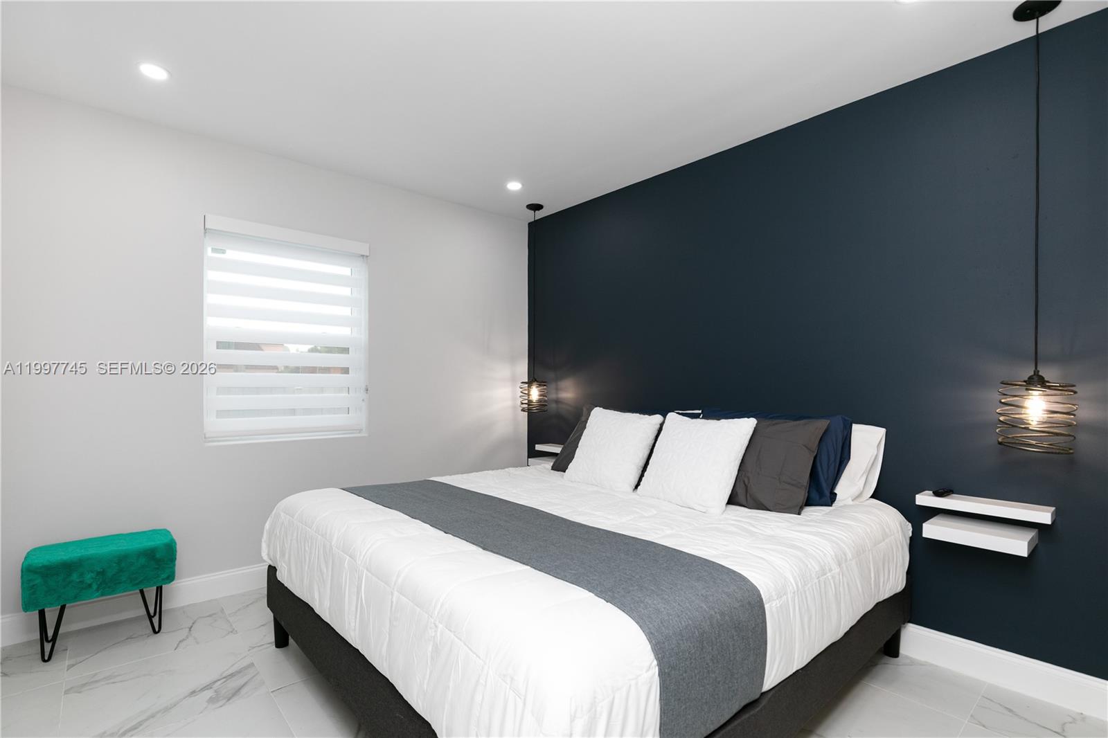 2376 Northwest 2nd Street Miami, FL 33125 - Photo 47 of 77 a bedroom with a bed and a chair