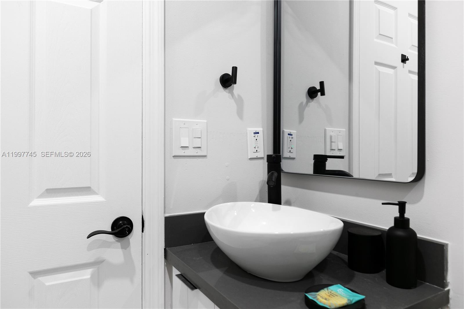 2376 Northwest 2nd Street Miami, FL 33125 - Photo 51 of 77 a bathroom with a granite countertop sink mirror vanity and toilet