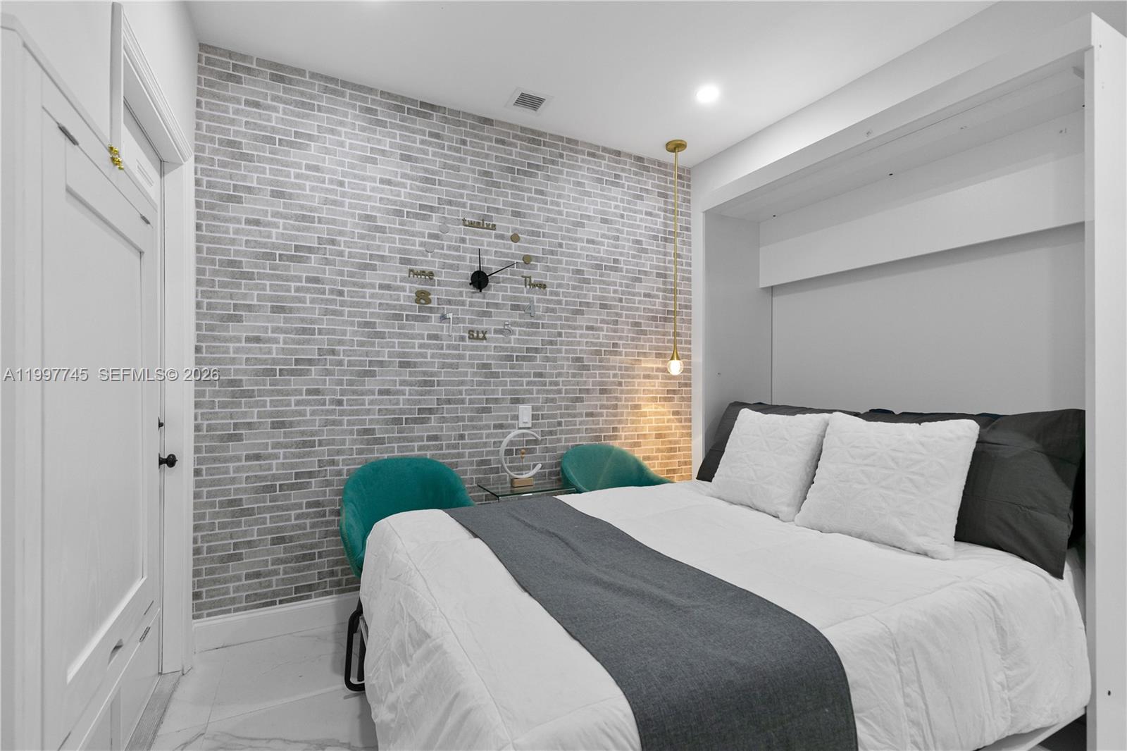 2376 Northwest 2nd Street Miami, FL 33125 - Photo 53 of 77 a bedroom with a bed and a chair