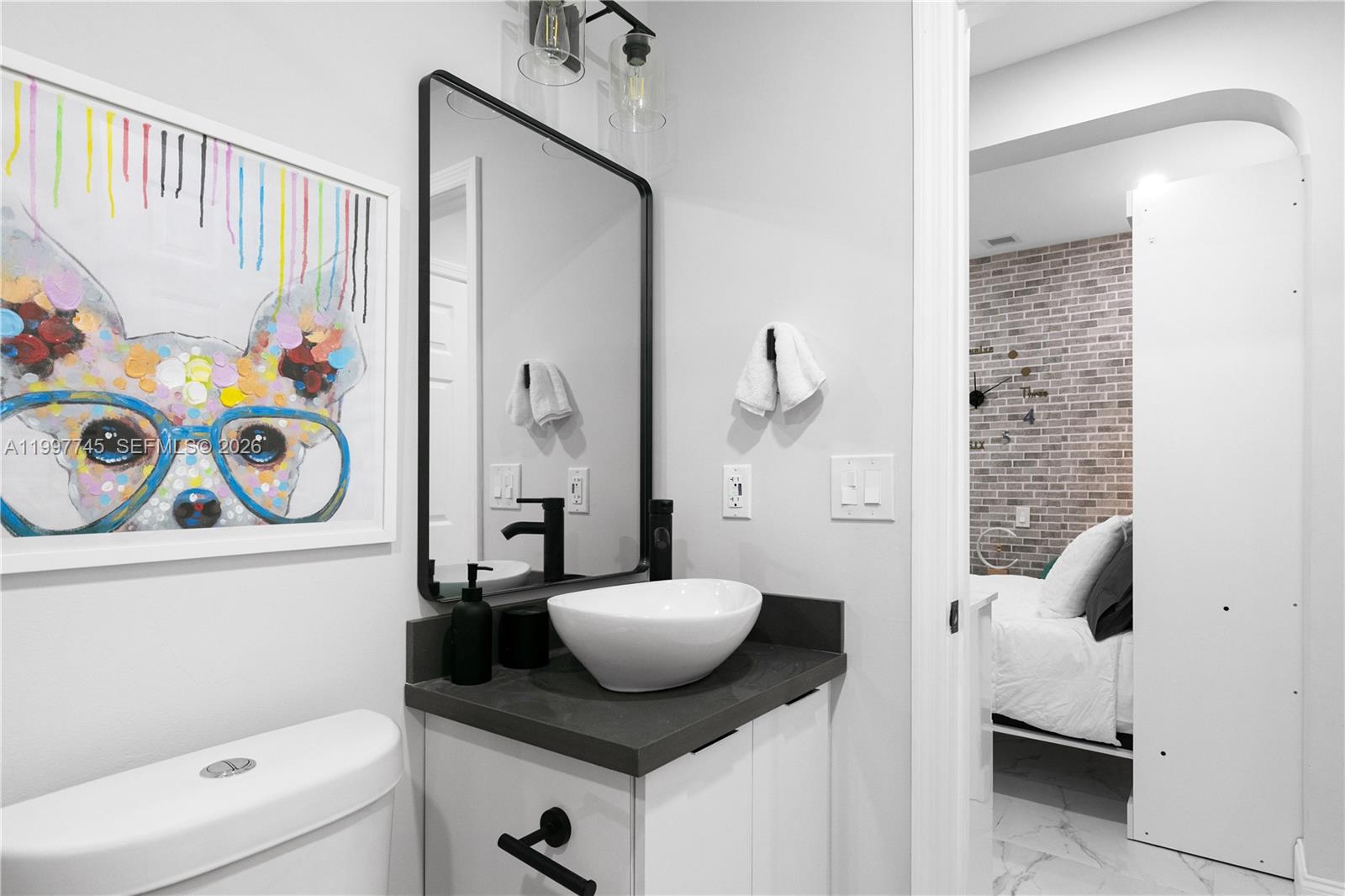 2376 Northwest 2nd Street Miami, FL 33125 - Photo 58 of 77 a bathroom with a granite countertop sink and a mirror