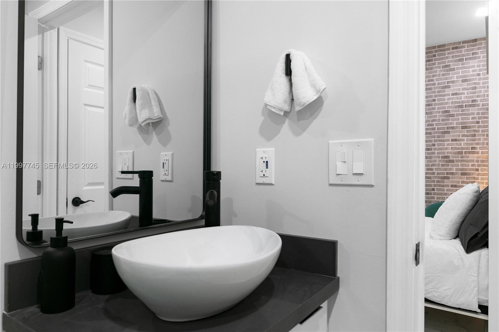 2376 Northwest 2nd Street Miami, FL 33125 - Photo 59 of 77 a bathroom with a sink and mirror with toilet