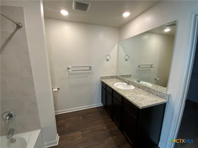 a bathroom with a granite countertop sink and a mirror