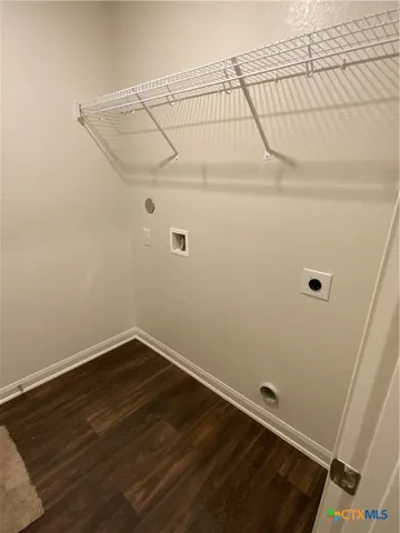 an empty room with wooden floor and white walls