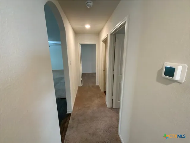 a view of a hallway with wooden shelves