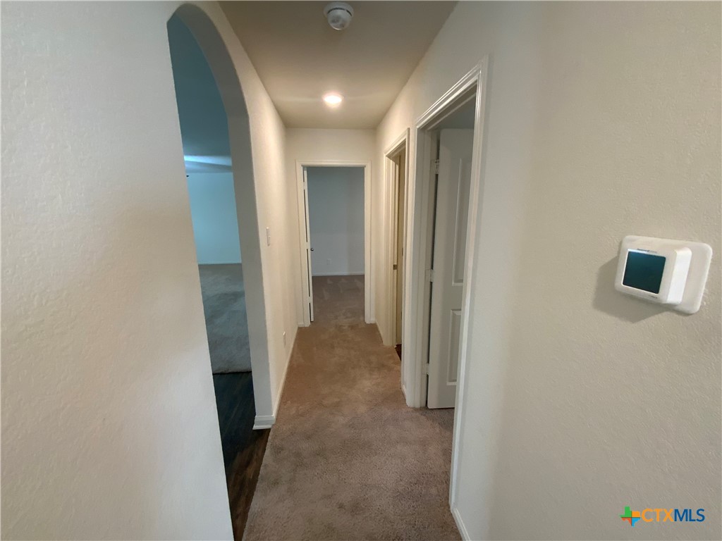 208 Allington Circle Jarrell, TX 76537 - Photo 4 of 16 a view of a hallway with wooden shelves