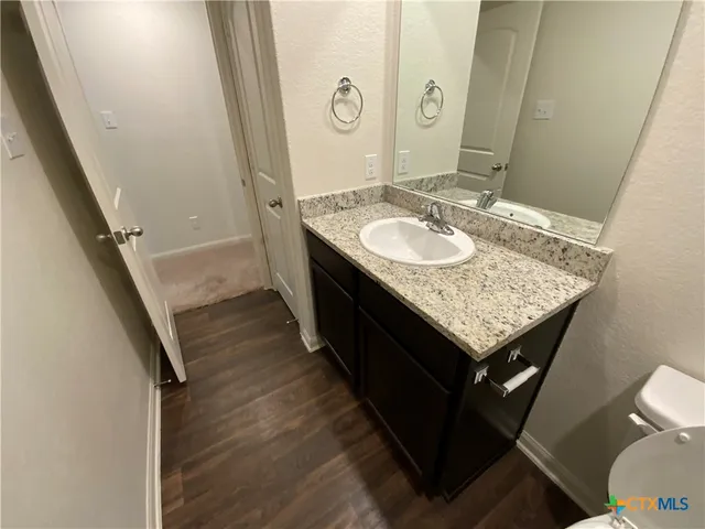 a bathroom with a granite countertop sink and a mirror
