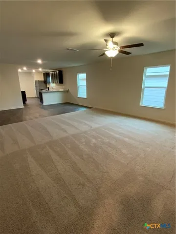 a view of a livingroom with a ceiling fan and window