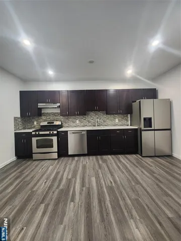 a large kitchen with a stove top oven and refrigerator