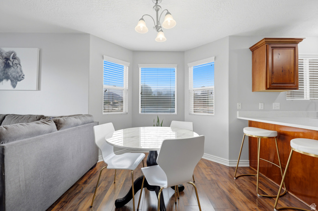 116 East Resaca Drive, Unit F6 Sandy, UT 84070 - Photo 15 of 32 Dining area featuring wood-finish flooring, a white round table, and a contemporary ceiling fixture