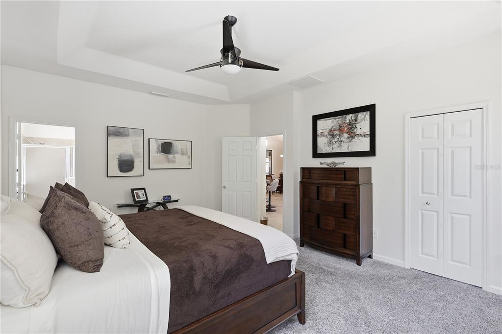 124 South Hummingbird Place Palm Coast, FL 32164 - Photo 13 of 47 a spacious bedroom with a bed and a chandelier