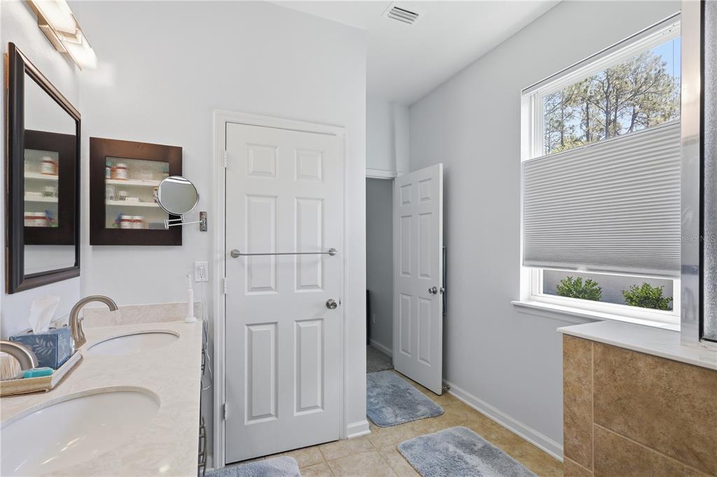 124 South Hummingbird Place Palm Coast, FL 32164 - Photo 17 of 47 a bathroom with a granite countertop tub shower and mirror