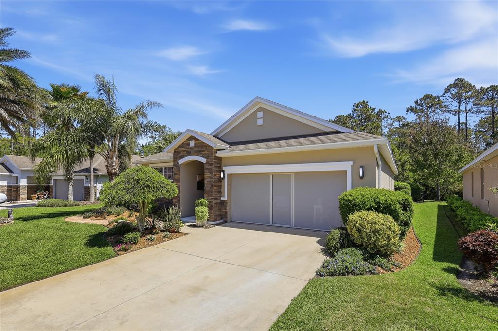124 South Hummingbird Place Palm Coast, FL 32164 - Photo 44 of 47 a front view of a house with a yard and garage