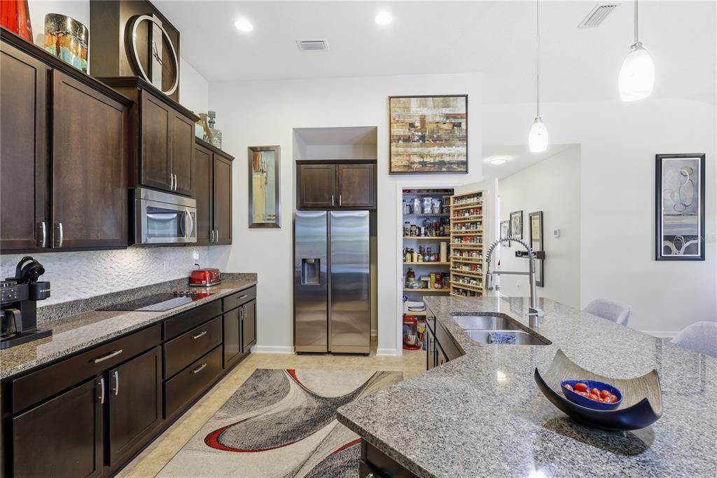 124 South Hummingbird Place Palm Coast, FL 32164 - Photo 7 of 47 a kitchen with stainless steel appliances granite countertop a sink refrigerator and cabinets
