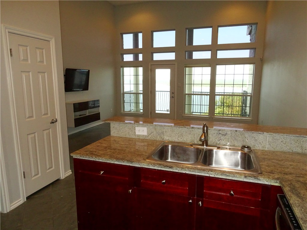 2918 Ranch Road 620, Unit K170 Austin, TX 78734 - Photo 6 of 22 A gleaming granite countertop frames a kitchen sink, overlooking a scenic lake view.