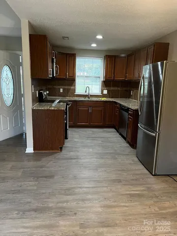 a kitchen with stainless steel appliances wooden cabinets and a refrigerator