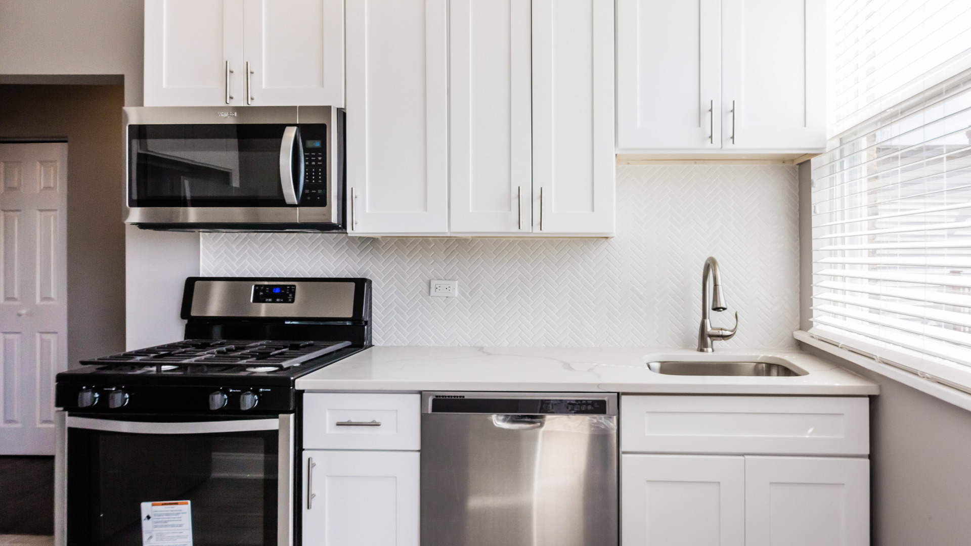 3903 West Belden Avenue, Unit 2 Chicago, IL 60647 - Photo 2 of 15 a kitchen with cabinets stainless steel appliances and a sink
