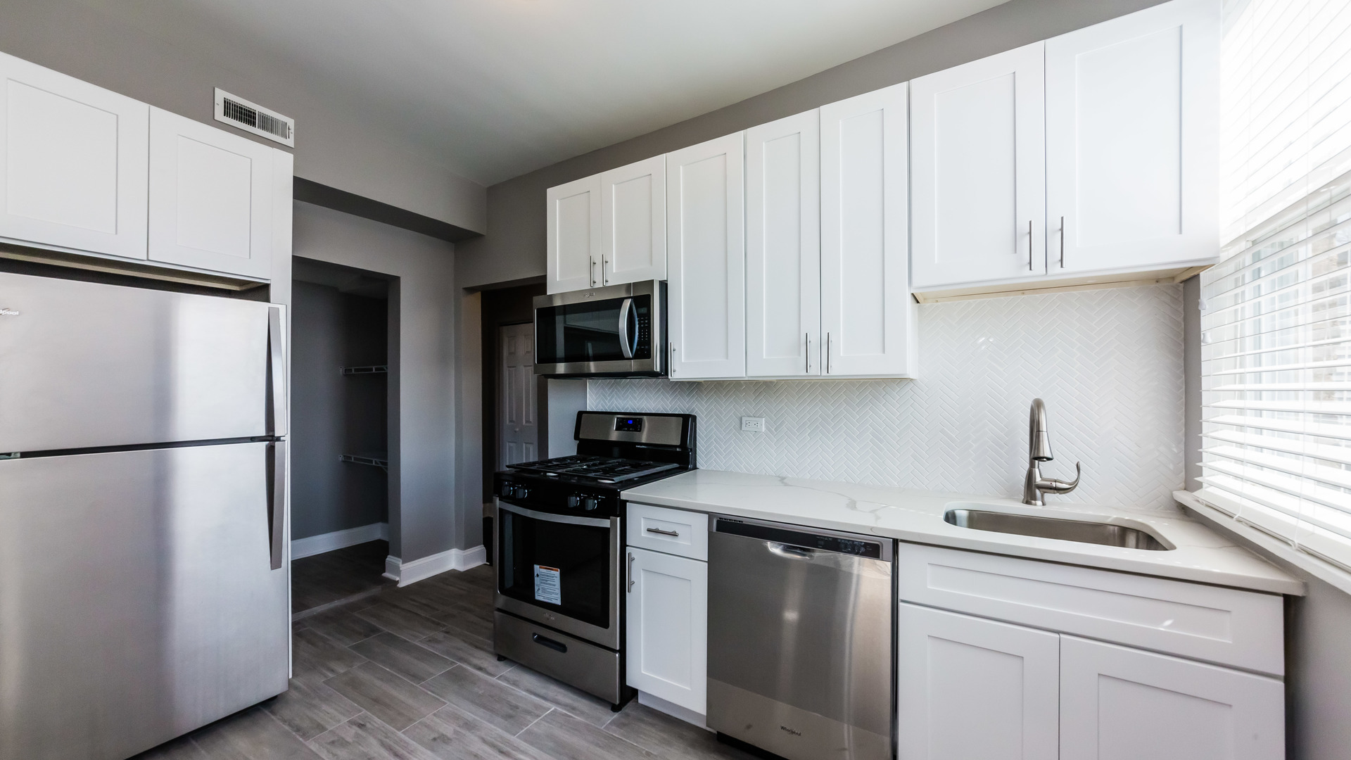 3903 West Belden Avenue, Unit 2 Chicago, IL 60647 - Photo 3 of 15 a kitchen with white cabinets and refrigerator
