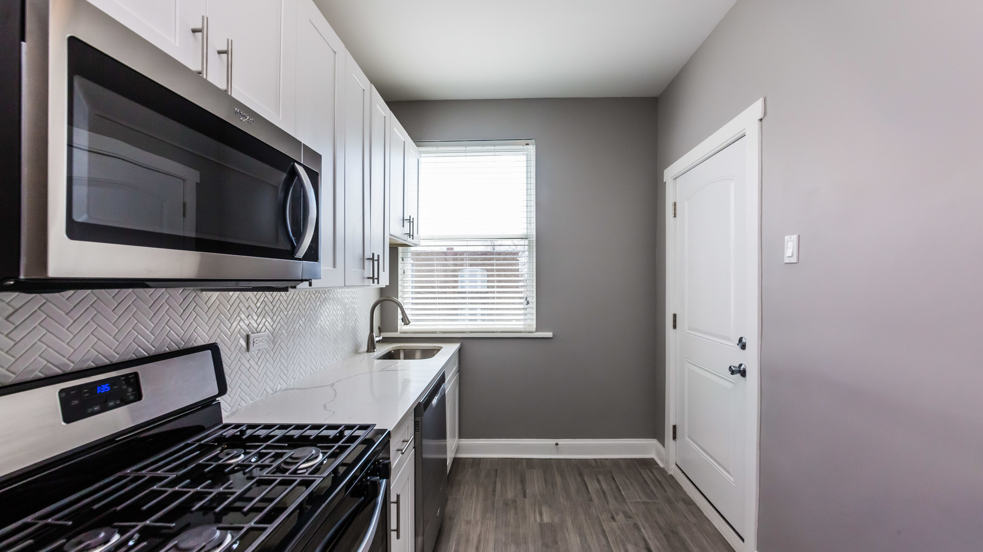 3903 West Belden Avenue, Unit 2 Chicago, IL 60647 - Photo 4 of 15 a kitchen with a stove and a microwave
