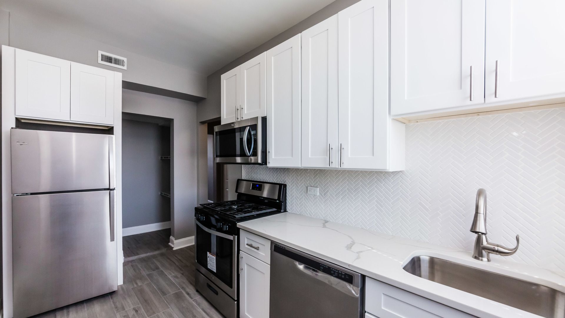 3903 West Belden Avenue, Unit 2 Chicago, IL 60647 - Photo 5 of 15 a kitchen with a refrigerator sink and cabinets