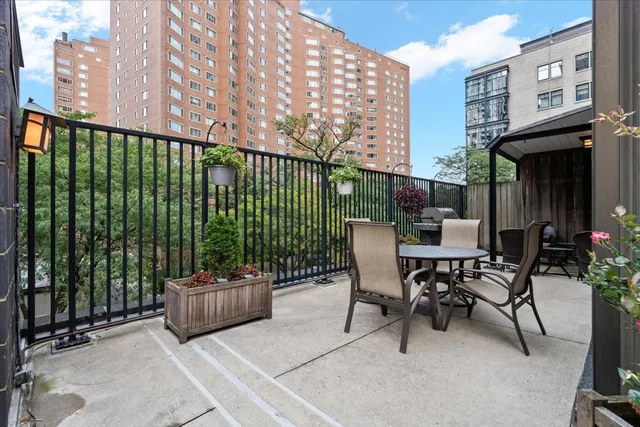 a view of a patio with a table and chairs and potted plants