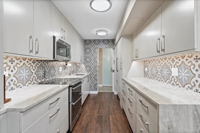 a kitchen with granite countertop a sink stove and cabinets