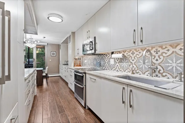 a kitchen with stainless steel appliances granite countertop a stove a sink and a refrigerator