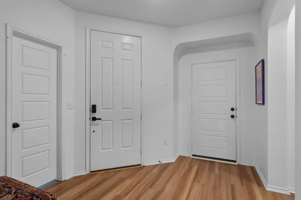 a view of a room with wooden floor and closet area