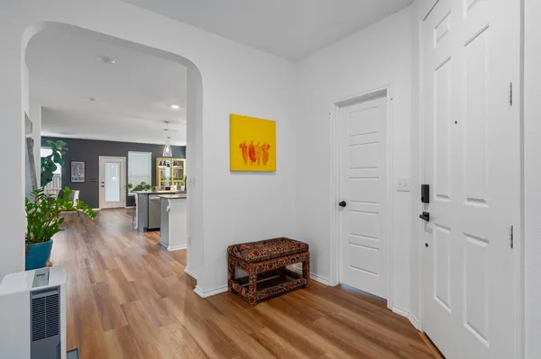 a hallway with a wooden floor and a potted plant
