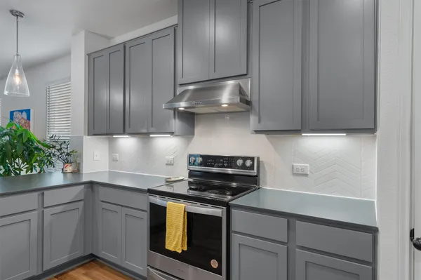 a kitchen with stainless steel appliances granite countertop a sink stove and cabinets