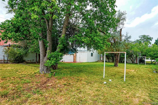 a backyard of a house with plants and wooden fence