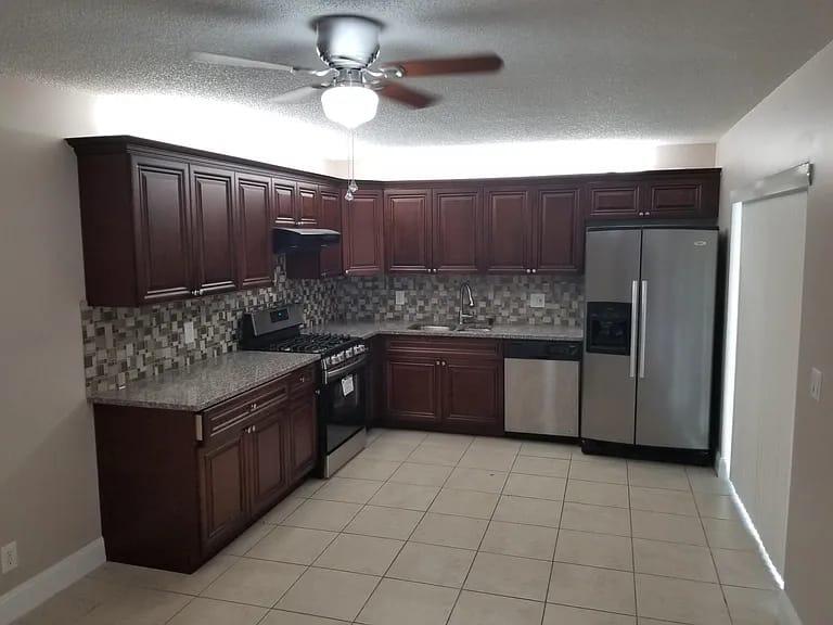 a kitchen with stainless steel appliances granite countertop a stove a refrigerator and a sink