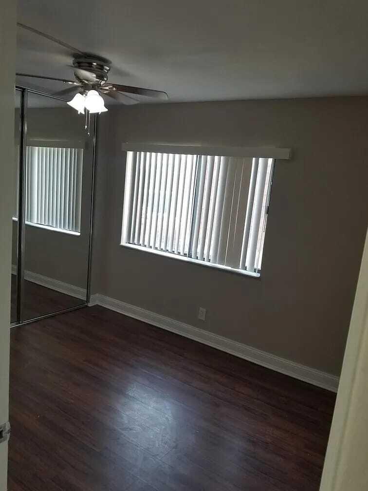 2184 White Pine Circle, Unit A Greenacres, FL 33415 - Photo 15 of 15 an empty room with wooden floor chandelier and windows
