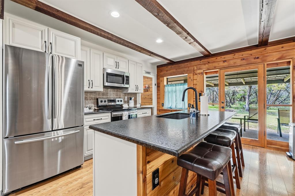 2731 Garrett Lane China Spring, TX 76633 - Photo 24 of 36 a kitchen with stainless steel appliances granite countertop a refrigerator a stove and a sink with wooden floor