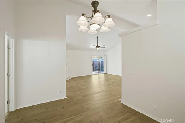 a view of a livingroom with a chandelier fan and wooden floor