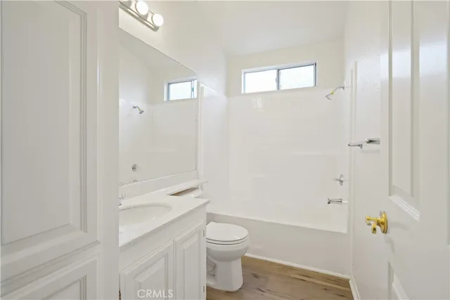 a bathroom with a granite countertop toilet a sink and shower