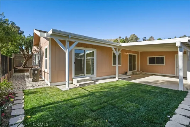 a backyard of a house with table and chairs