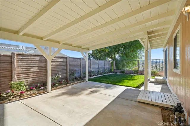 a view of a backyard with couches plants and large tree