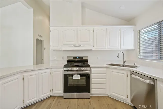 a kitchen with granite countertop white cabinets and stainless steel appliances