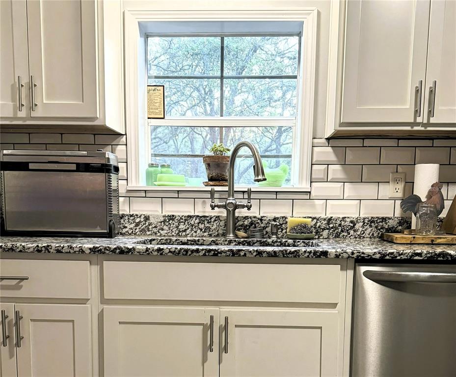 16314 Tiger Trail Spring Hill, FL 34610 - Photo 6 of 11 a kitchen with stainless steel appliances white cabinets and a window
