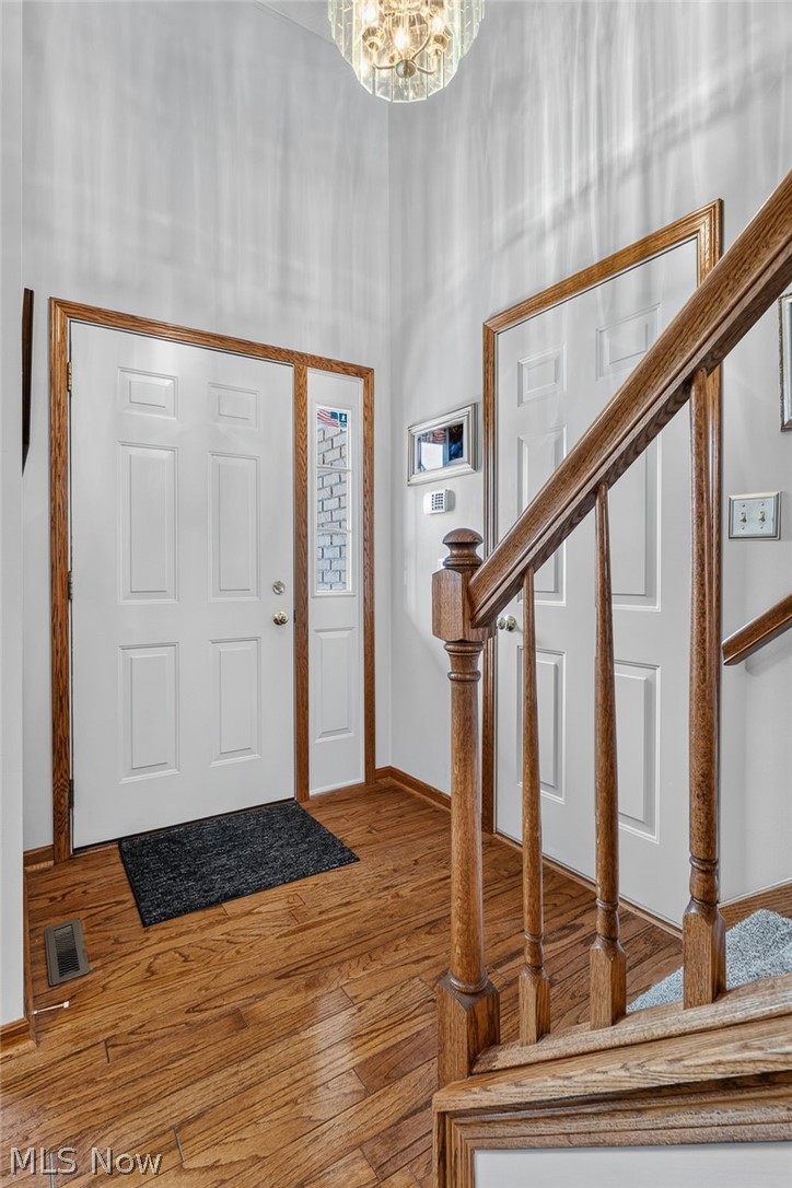 2601 Charing Cross Road Northwest Canton, OH 44708 - Photo 25 of 49 Hardwood flooring, white panel doors with wood trim, and a crystal chandelier
