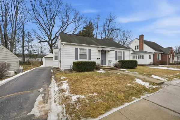 a front view of a house with a yard covered in snow