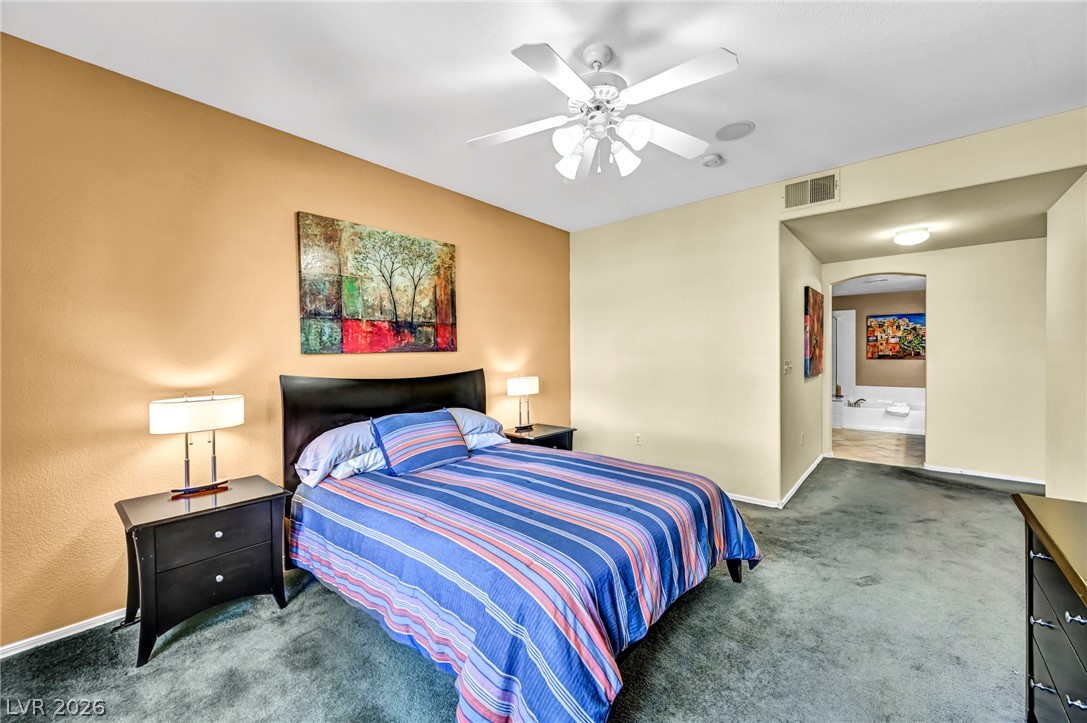 10730 Amber Ridge Drive, Unit 101 Las Vegas, NV 89144 - Photo 21 of 32 A well-appointed sleeping sanctuary, this room features comfortable carpeting and a direct entryway to the primary bathroom.