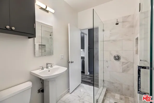 a bathroom with a sink a toilet and shower