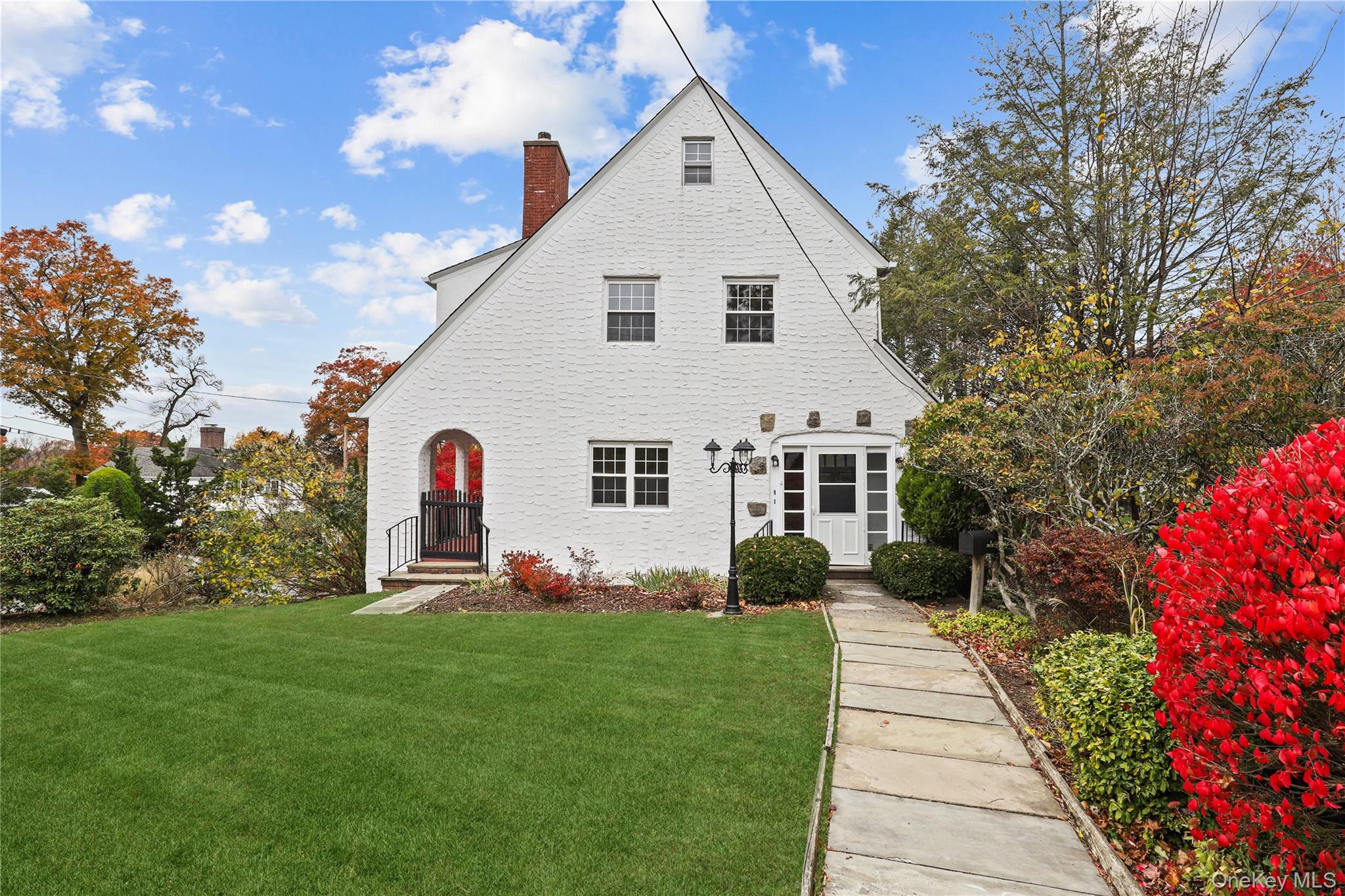 a front view of a house with a garden and plants
