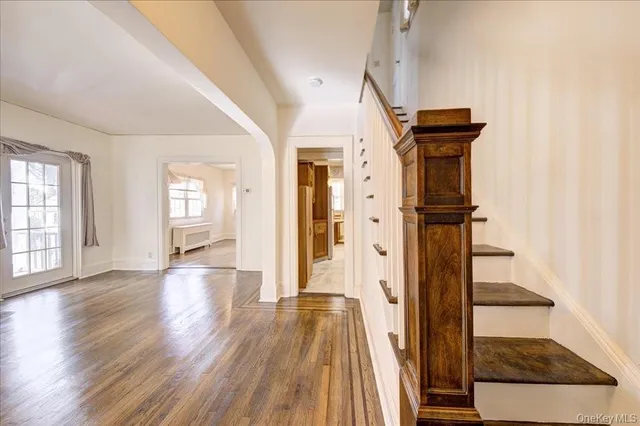 a view of a hallway with wooden floor and staircase