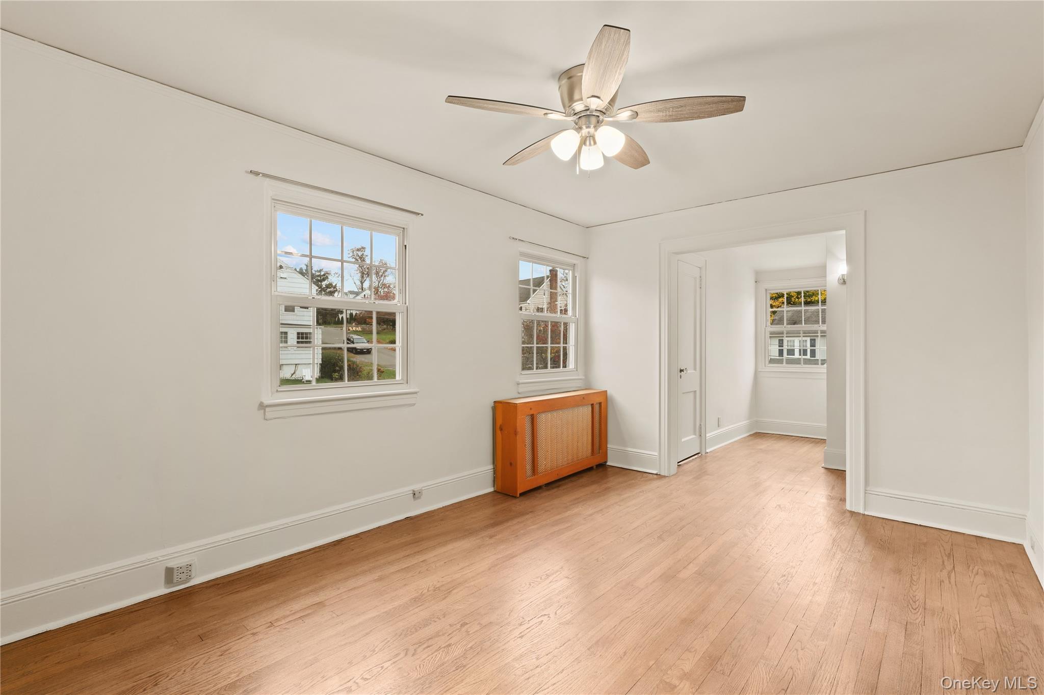 1 Rutgers Place Scarsdale, NY 10583 - Photo 25 of 29 a view of an empty room with chandelier fan and wooden floor
