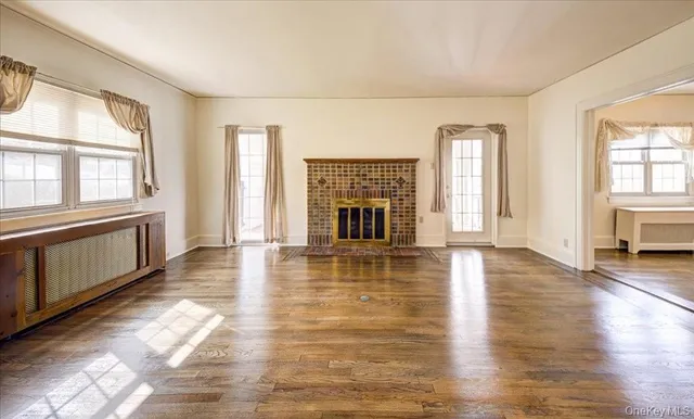 an empty room with floor to ceiling windows and fireplace