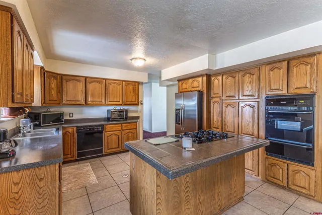 a kitchen with stainless steel appliances granite countertop a stove refrigerator and cabinets